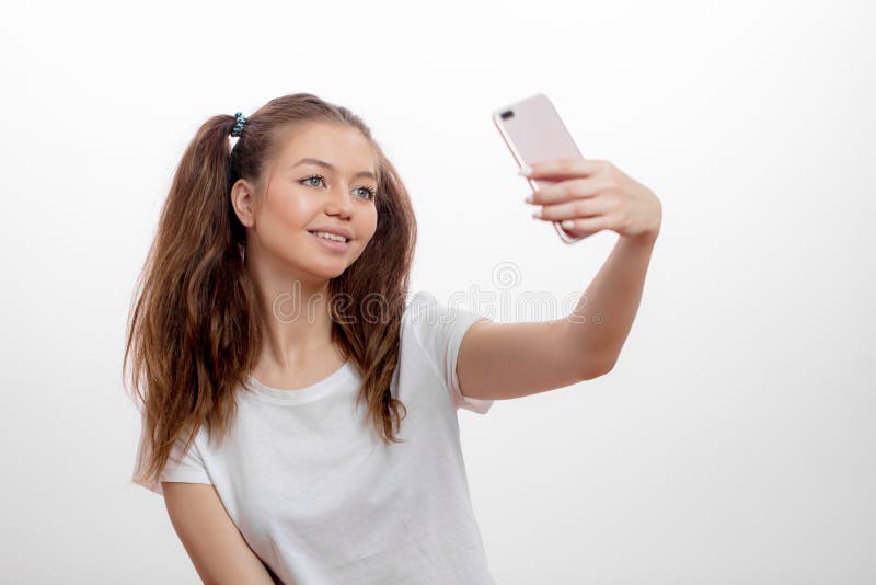 Stilvolle lächelnde junge Frau, die selfie mit ihrem intelligenten Telefon nimmt stockfoto Stilvolle lächelnde junge Frau, die selfie mit ihrem intelligenten Telefon nimmt stockfoto