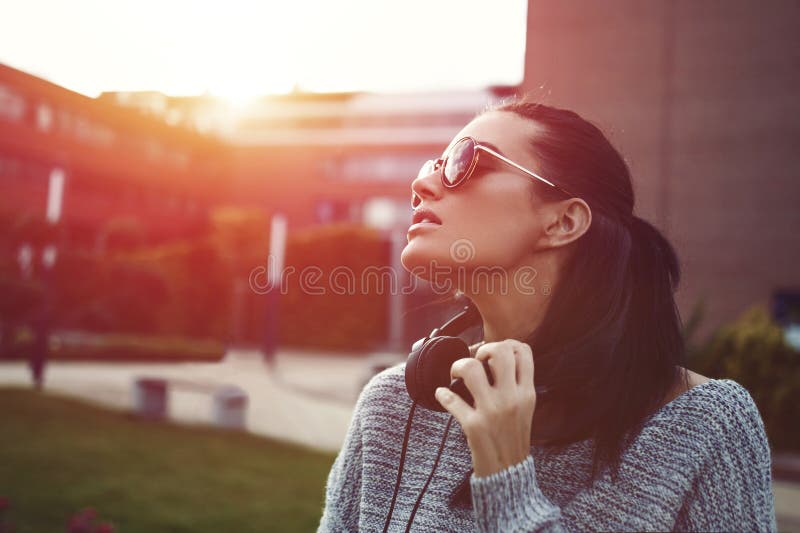 Stilvolle modische städtische Frau, die Sonnenuntergang in der Sonnenbrille genießt stockfoto Stilvolle modische städtische Frau, die Sonnenuntergang in der Sonnenbrille genießt stockfoto
