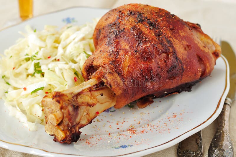 Stinco arrostito della carne di maiale con l'insalata di cavolo fresca immagine stock libera da diritti Stinco arrostito della carne di maiale con l'insalata di cavolo fresca immagine stock libera da diritti
