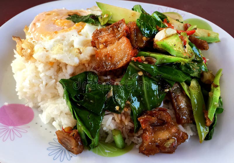 StirFried Kale Vegetable with Crispy Pork and Fried Egg Over Rice