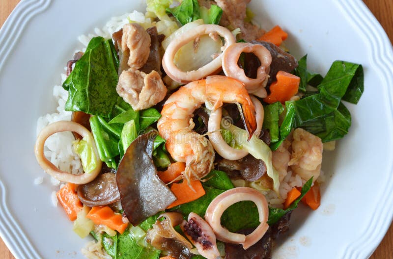 Stir Fried Mixed Vegetable with Seafood and Pork on Rice Stock Photo
