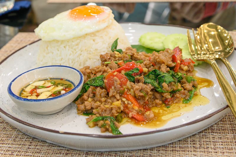 Stir Fried Thai Basil with Minced Pork and a Fried Egg on White Plate
