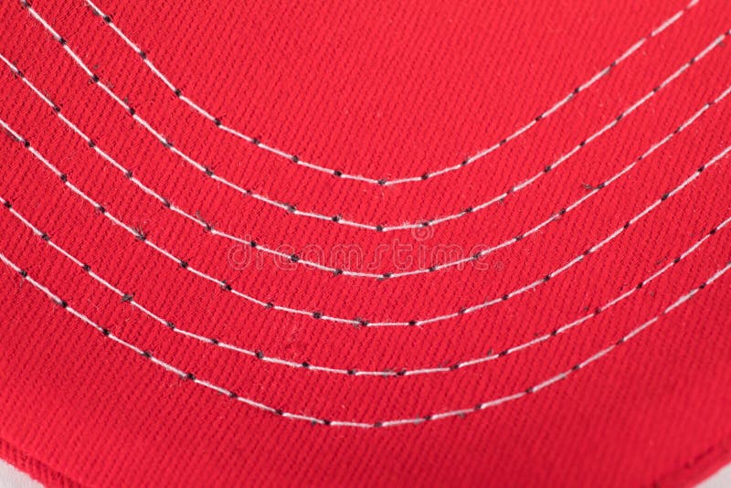 Stitching of white thread on a read cloth or material for background.