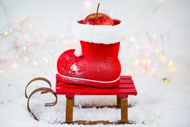 Stivali di Santa Claus con i dadi, mandarini, mele, nella neve fotografia stock libera da diritti Stivali di Santa Claus con i dadi, mandarini, mele, nella neve fotografia stock libera da diritti