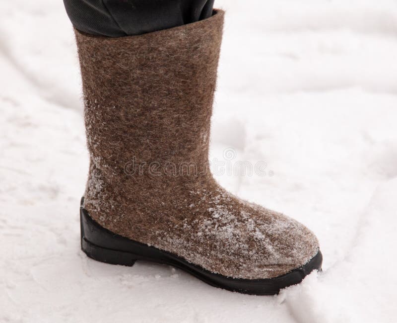 Stivali sui piedi di un uomo nell'inverno fotografie stock Stivali sui piedi di un uomo nell'inverno fotografie stock