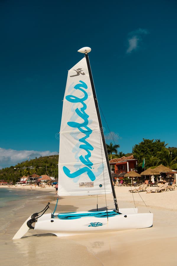 Stjohns, Antígua - 5 de março de 2017: yacht na água e na costa de mar arenosa na praia ensolarada iate das sandálias para turist imagem de stock Stjohns, Antígua - 5 de março de 2017: yacht na água e na costa de mar arenosa na praia ensolarada iate das sandálias para turist imagem de stock