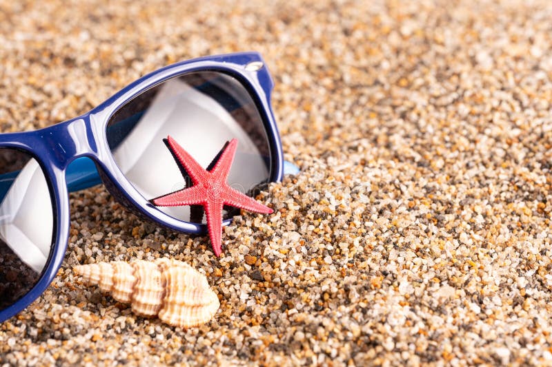 Starfish and sunglasses on beach, closeup. Travel concept. Starfish and sunglasses on beach, closeup. Travel concept