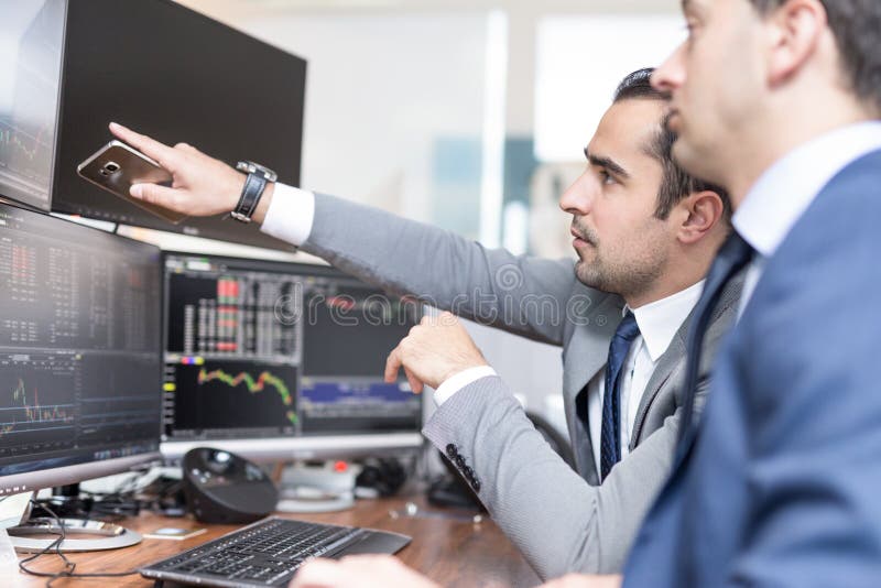 Stock brokers looking at computer screens, trading online.