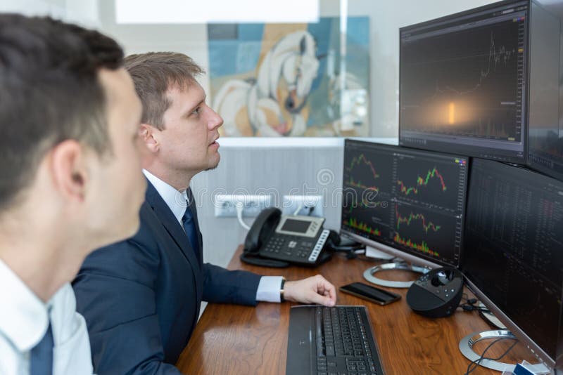 Stock brokers looking at computer screens, trading online.