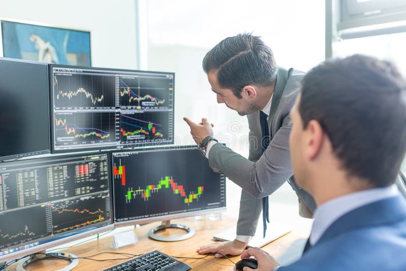 Stock brokers looking at computer screens, trading online.