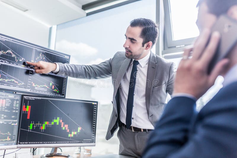 Stock brokers looking at computer screens, trading online.