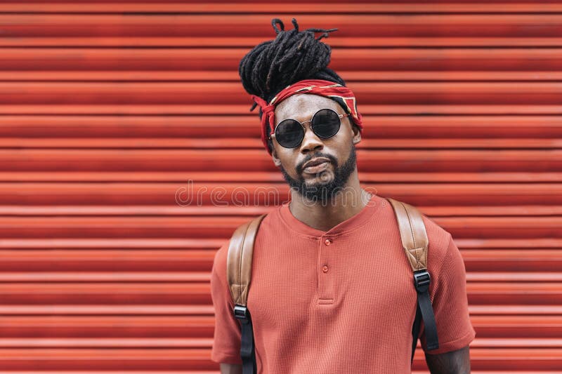 Cheerful young man wearing red bandana while looking away in city stock  photo - OFFSET