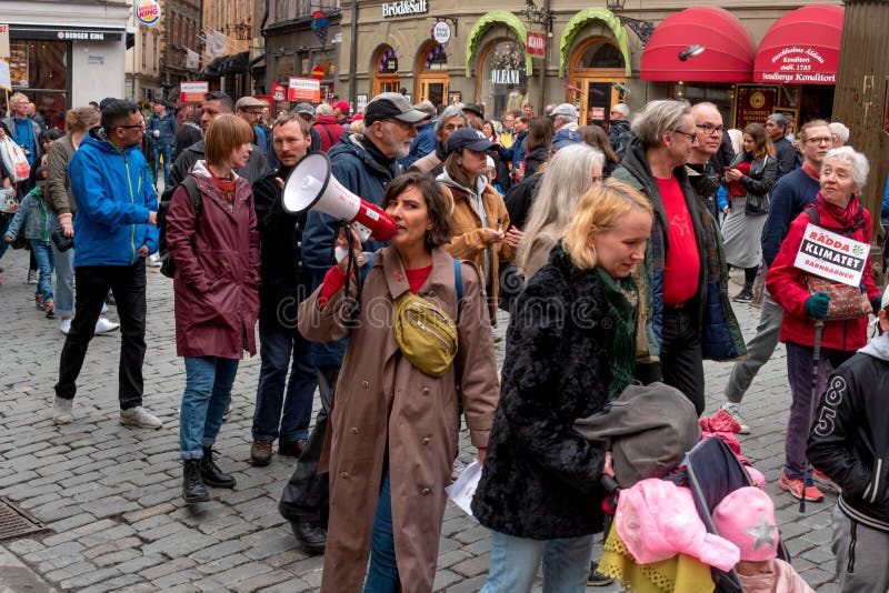 Stockholm, Sverige - 1 maj 2019: Demonstration på arbetsdagen i Stockholm i maj Människor bär röda banderoller royaltyfri bild Stockholm, Sverige - 1 maj 2019: Demonstration på arbetsdagen i Stockholm i maj Människor bär röda banderoller royaltyfri bild
