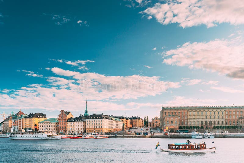Stockholm, Sweden. Touristic Boat Floating Near Famous Embankment In Old Town Gamla Stan In Summer Evening. Famous