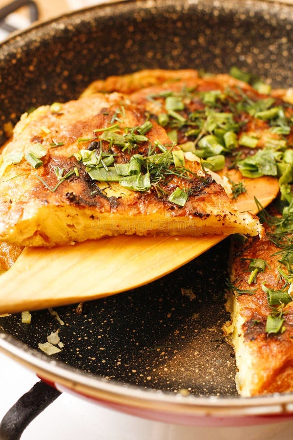 Stodgy Spanish Potato Tortilla with Herbs in Black Pan Stock Image