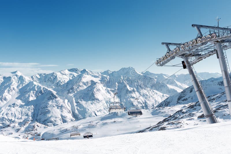 Stoeltjeslift in de Alpiene skitoevlucht Steun en lege zetels Snow-capped bergpieken royalty-vrije stock foto's Stoeltjeslift in de Alpiene skitoevlucht Steun en lege zetels Snow-capped bergpieken royalty-vrije stock foto's