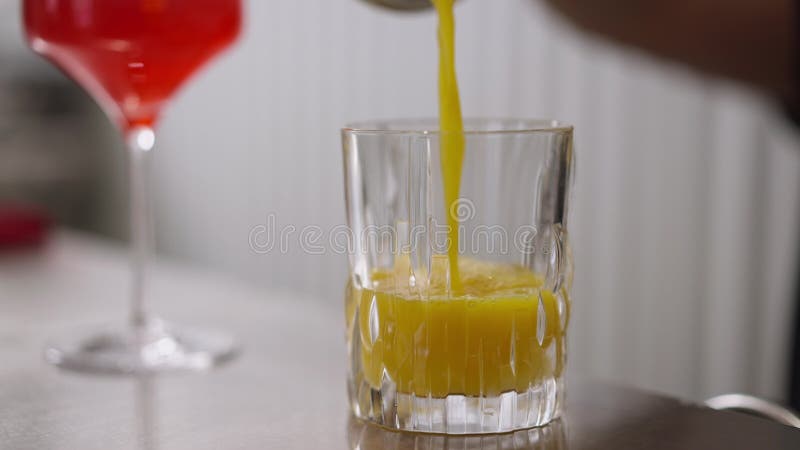 Stolling die de gele, gezonde vitaminescocktail uit het glas in langzaam beweging spoelt. onherkenbaar