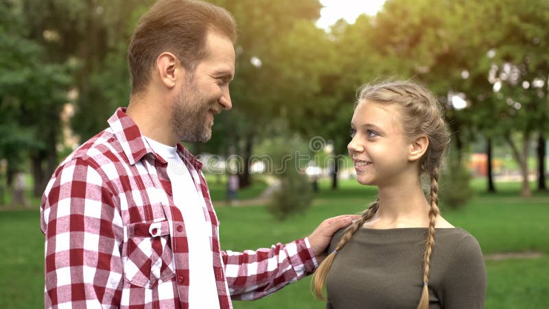 Stolt fader som ser dottern som gratulerar med universitettillträdeet, framgång arkivbild