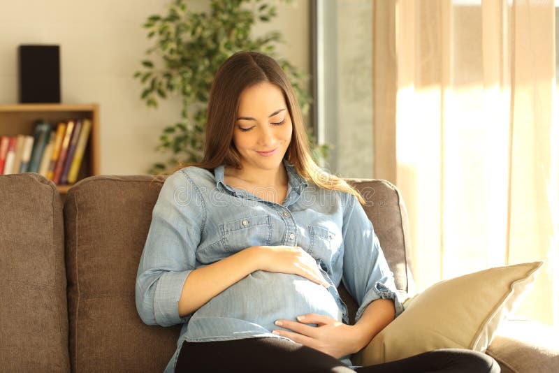 Stolze schwangere Frau, die ihren Bauch schaut lizenzfreies stockfoto Stolze schwangere Frau, die ihren Bauch schaut lizenzfreies stockfoto