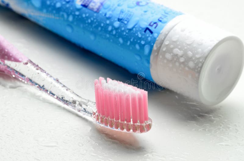 Photograph of a tube of toothpaste and a toothbrush showing dental hygiene. Photograph of a tube of toothpaste and a toothbrush showing dental hygiene