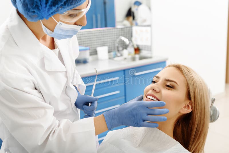 Stomatologist checking oral cavity of client after treating teeth