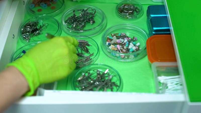 Stomatologist choisissant des instruments pour traiter des dents de patients, aide professionnelle photos stock Stomatologist choisissant des instruments pour traiter des dents de patients, aide professionnelle photos stock