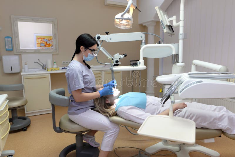Stomatologist Examining Teeth of Patient with Help of Professional
