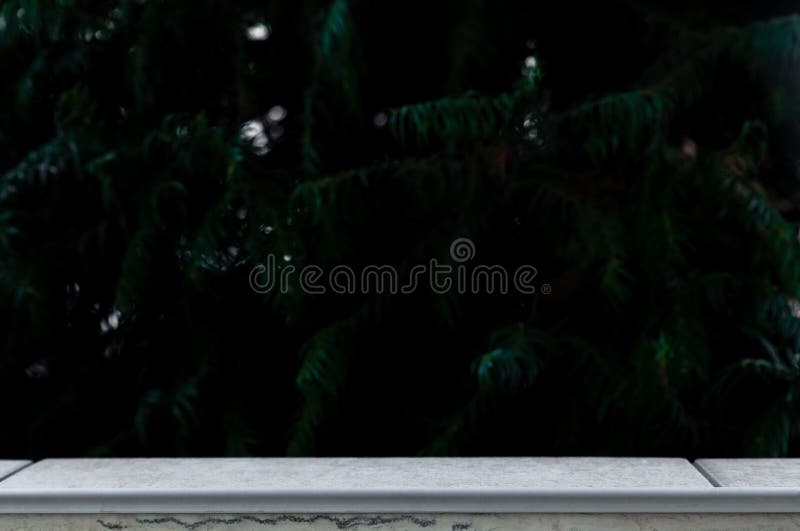 Stone board empty table in front of blurred forest background. Perspective white marble over blur - can be used for display or royalty free stock photography Stone board empty table in front of blurred forest background. Perspective white marble over blur - can be used for display or royalty free stock photography