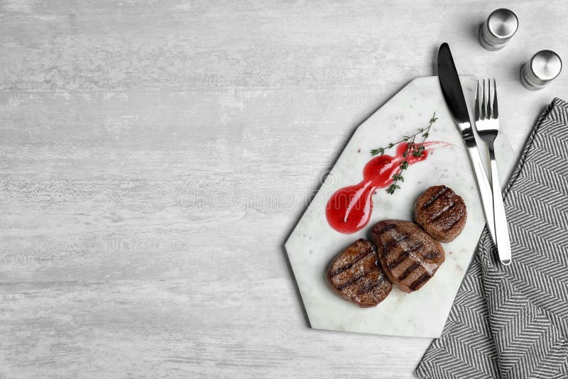 Stone board with grilled meat and sauce on light background, top view. royalty free stock photography Stone board with grilled meat and sauce on light background, top view. royalty free stock photography