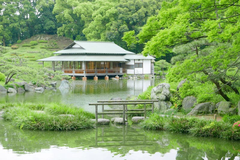 Stone bridge with reflection and pavilion building in zen garden