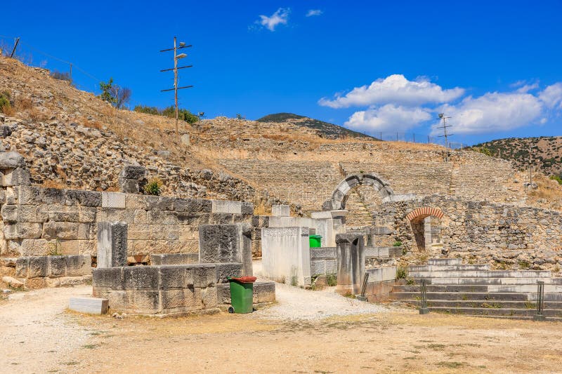A stone building with a green trash can in front of it. Ruins of the ancient city of Philippi, Greece royalty free stock photos