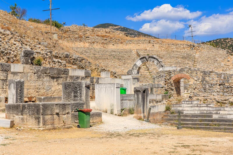 A stone building with a green trash can in front of it. Ruins of the ancient city of Philippi, Greece stock photography