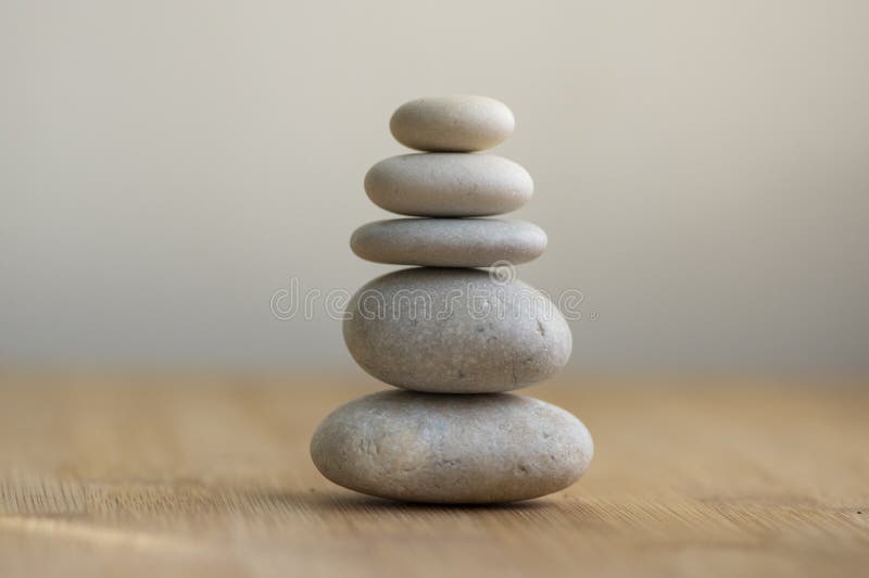 Stone cairn on striped grey white background, five stones tower, simple poise stones, simplicity harmony and balance