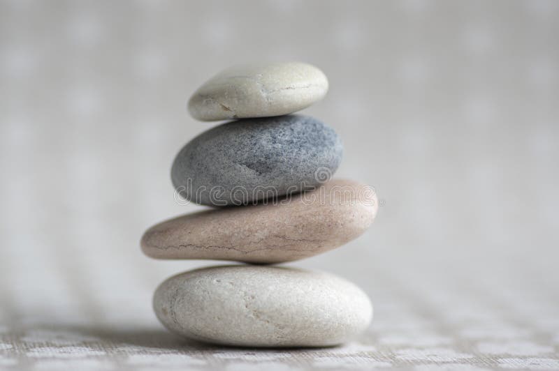 Stone cairn on striped grey white background, four stones tower, simple poise stones, simplicity harmony and balance