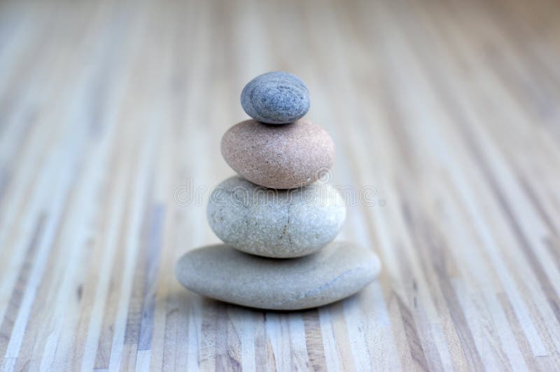 Stone cairn on striped grey white background, four stones tower, simple poise stones, simplicity harmony and balance, rock zen