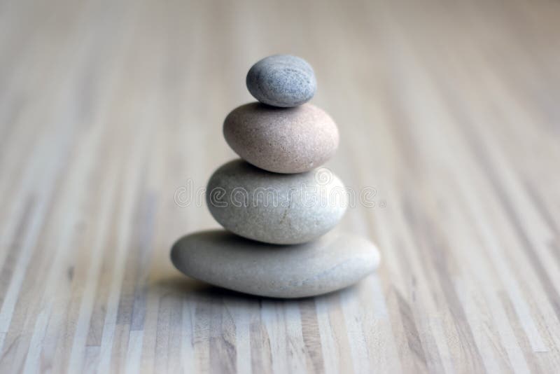 Stone cairn on striped grey white background, four stones tower, simple poise stones, simplicity harmony and balance, rock zen