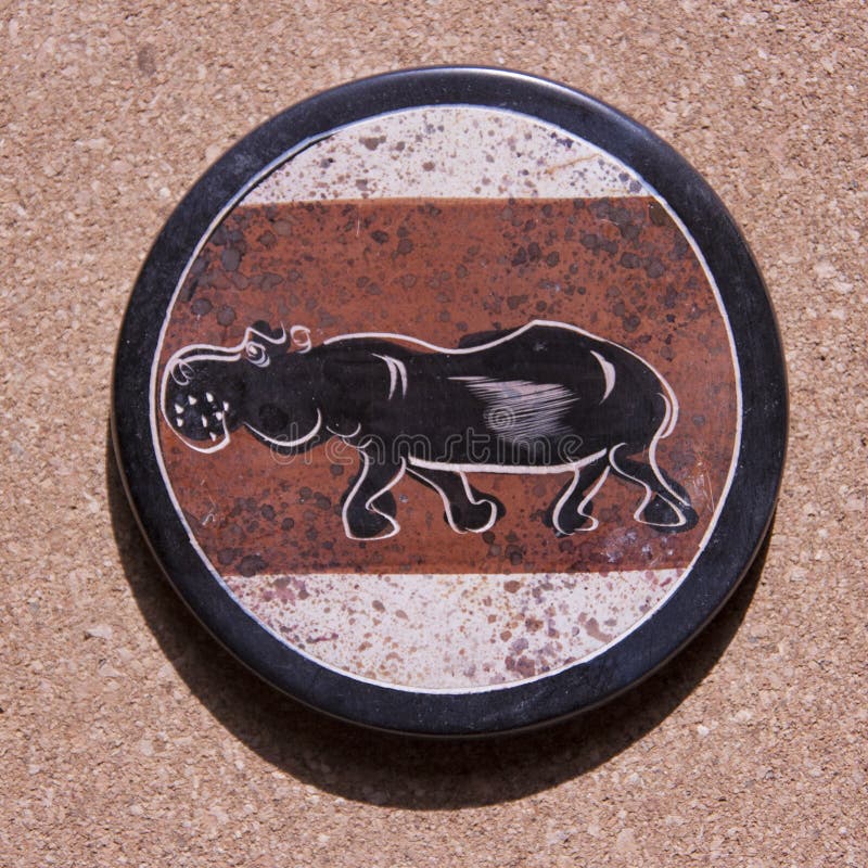 Stone coaster from Africa with an hippo painted on top royalty free stock images Stone coaster from Africa with an hippo painted on top royalty free stock images
