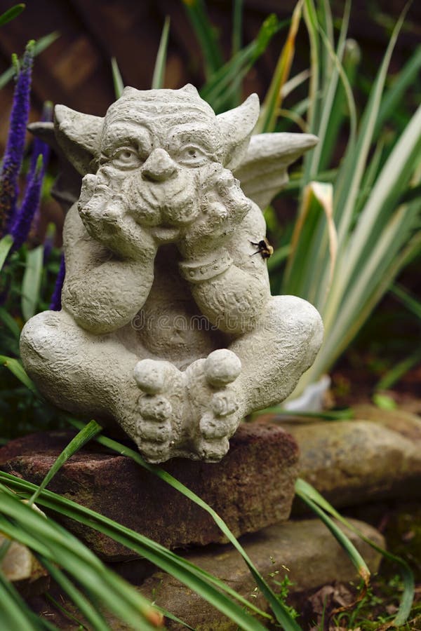 Stone Gargoyle In The Garden Stock Image Image of garden, purple