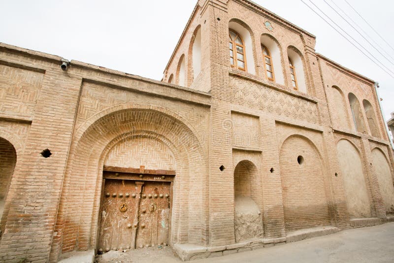 Stone house in the Iranian style masonry and wooden door in a narrow street of the old city