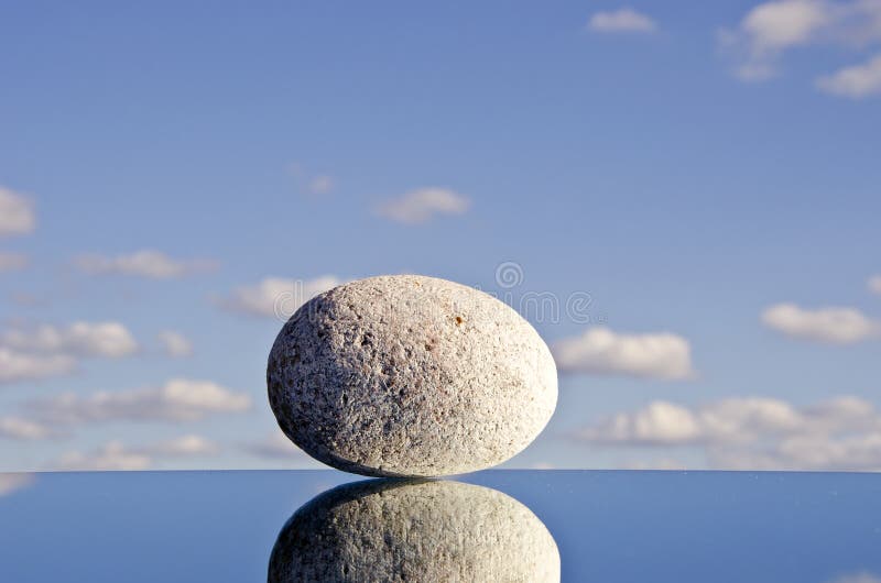 Stone on the mirror and sky