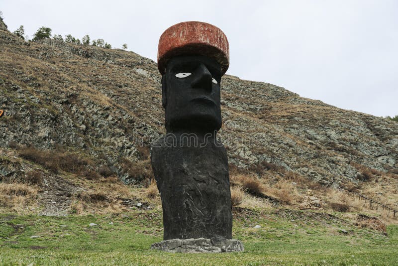 Stone Statue in a Red Hat is Buried in the Ground Editorial Photo