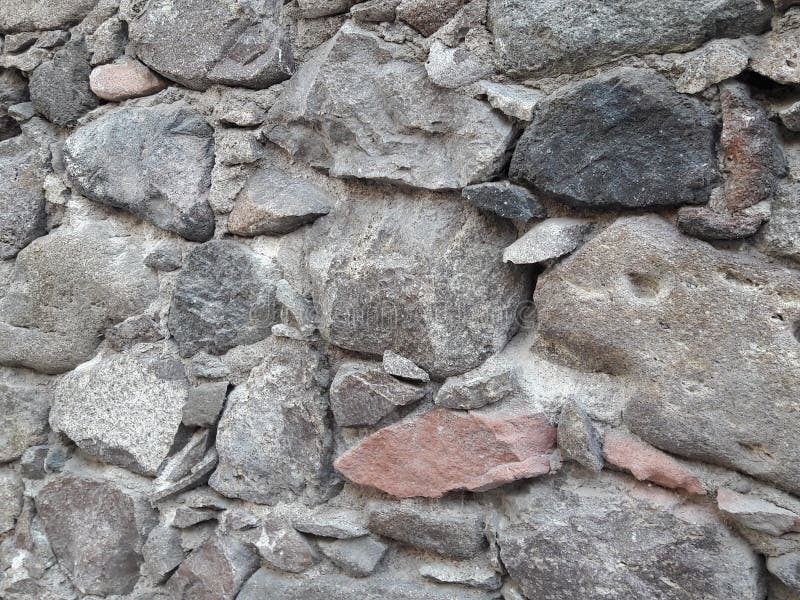 Stone Textured Background Created From Old Handcrafted Wall with Gray, Pink, Black Colored Rocks Laid in a Rustic Mexican Architectural Style. Typical old-world art and architecture using rocks instead of bricks in San Miguel de Allende, Mexico neighborhoods. Stable rustic style stock images, royalty-free photos and pictures