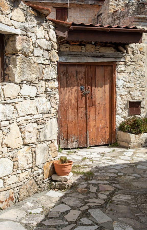 Stoned footpath crossing a traditional village. Stoned houses with wooden doors. Vintage architecture. Lofou village, Cyprus