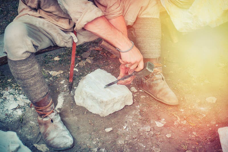Stonemason in the quarry has a chisel stones. Mason working with a stone of white limestone stock image