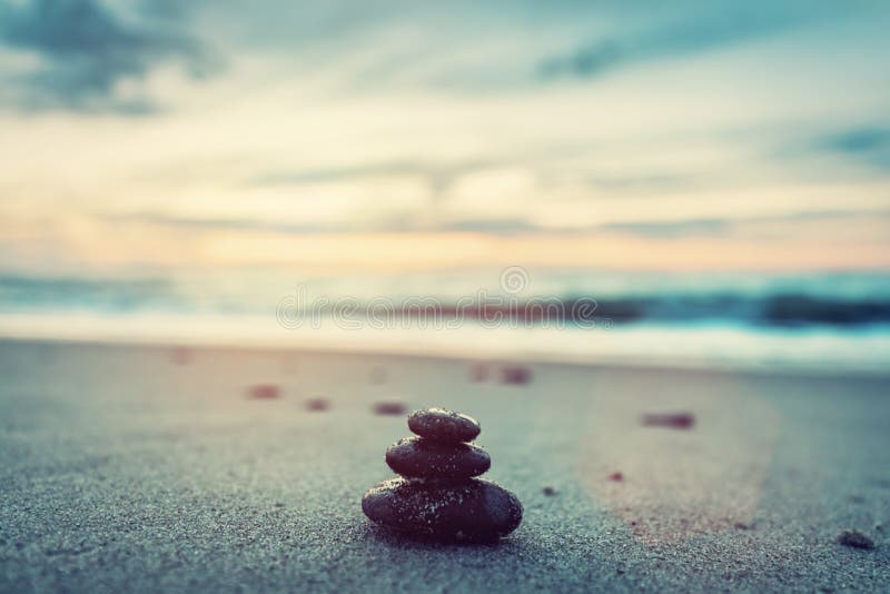 Stones pyramid on the beach at sunset. Zen