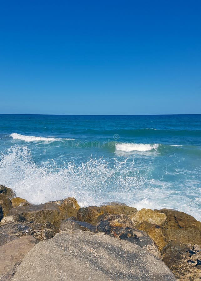 Stony seashore in turbulent weather, the waves roll ashore forms a white foam stock photos Stony seashore in turbulent weather, the waves roll ashore forms a white foam stock photos