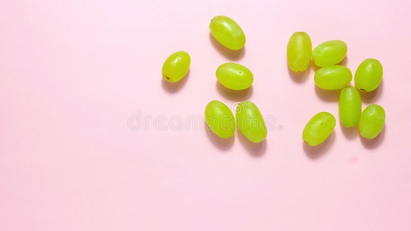Stop motion animation. Green grape berries move across the pink background. stock video footage