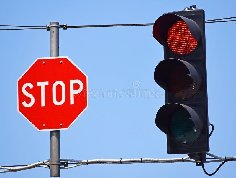 Stop sign and red light at the road crossing