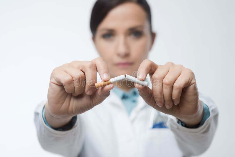 Aufhören zu Rauchen-Konzept mit weiblichen Arzt bricht eine Zigarette.