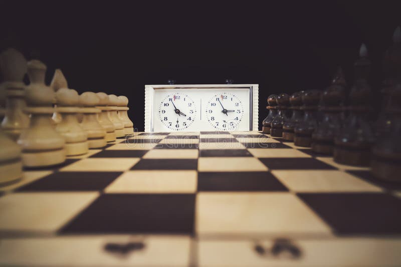 A Stopwatch and a Chessboard with a Game in Progress the Beginning of